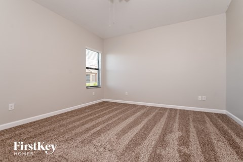 a spacious living room with carpet and a window