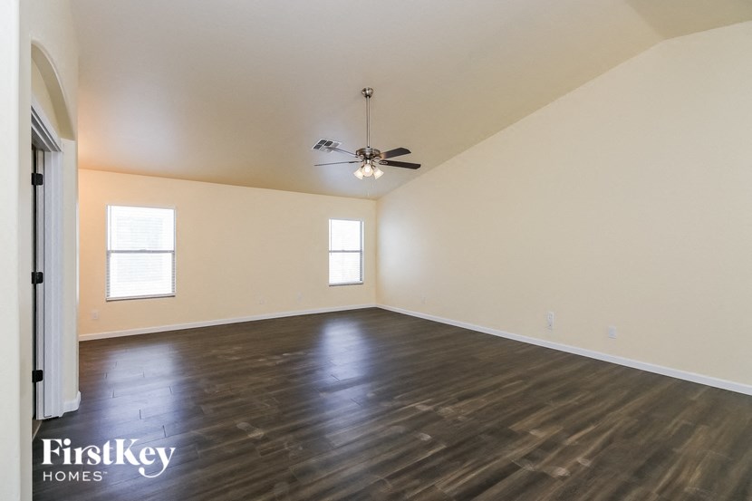 A room with wooden floors and a ceiling fan.