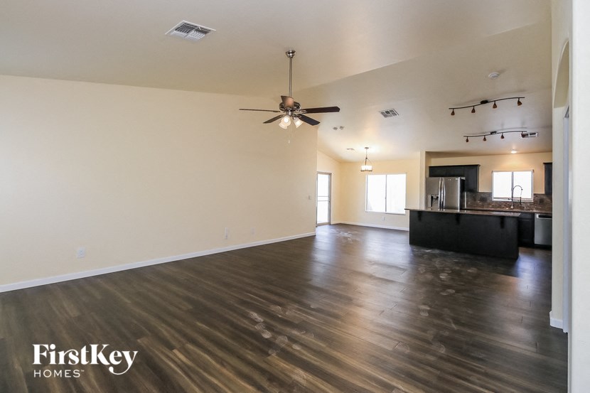 A spacious room with wooden floors and a ceiling fan.