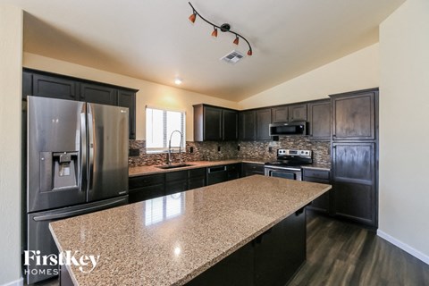 A kitchen with a granite countertop and a refrigerator.
