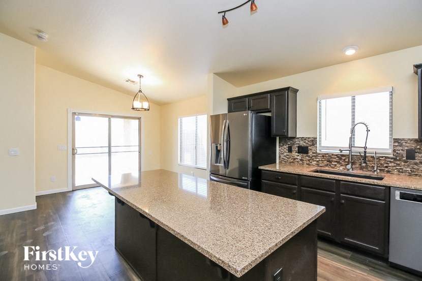 A kitchen with a granite countertop and stainless steel appliances.
