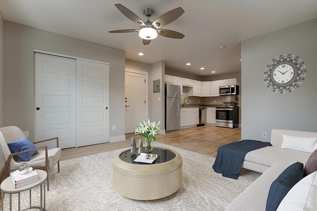 an open living room and kitchen with a large clock on the wall