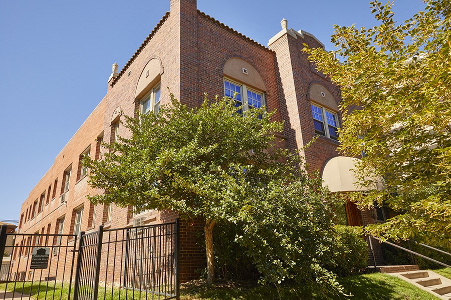 a large brick building with a tree in front of it