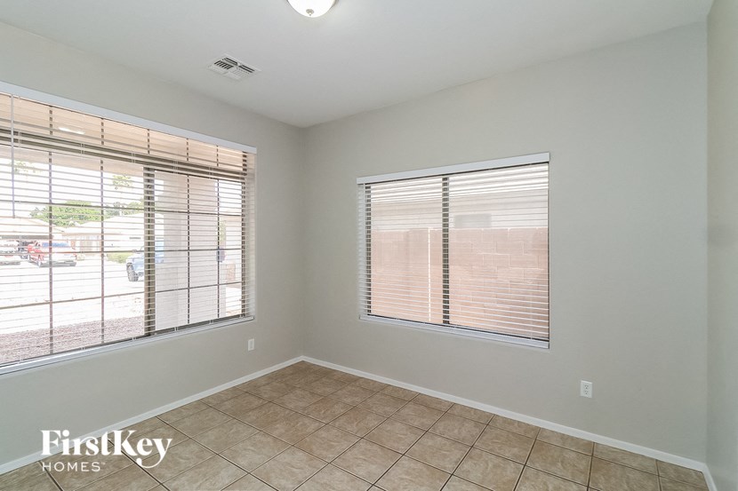 an empty room with two windows and a tiled floor
