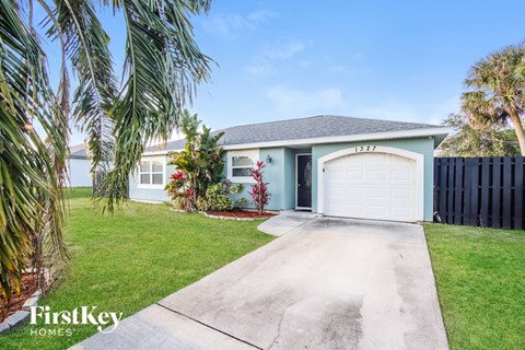 a blue house with a driveway and a garage door