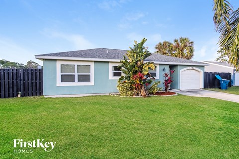 a light blue house with a lawn and a garage