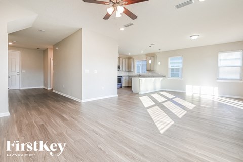 A spacious room with a ceiling fan and wooden flooring.