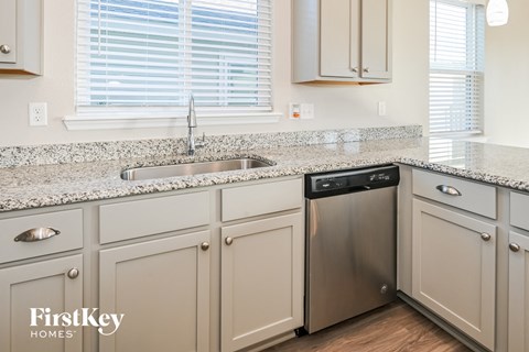 A kitchen with a stainless steel dishwasher and a sink.
