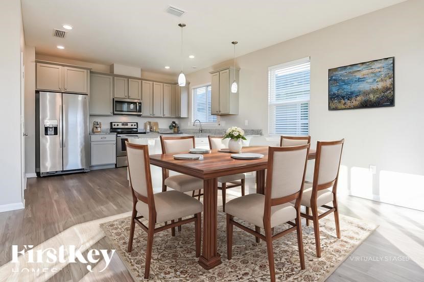 A dining room with a wooden table and chairs.