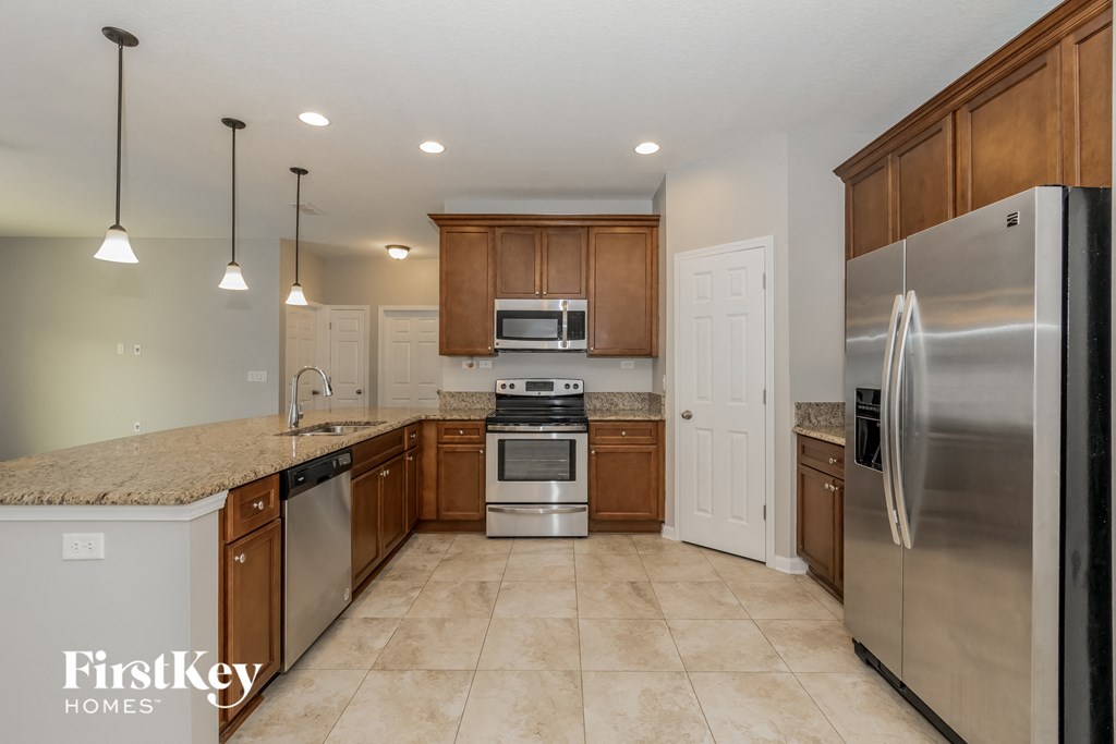 a kitchen with stainless steel appliances and marble counter tops