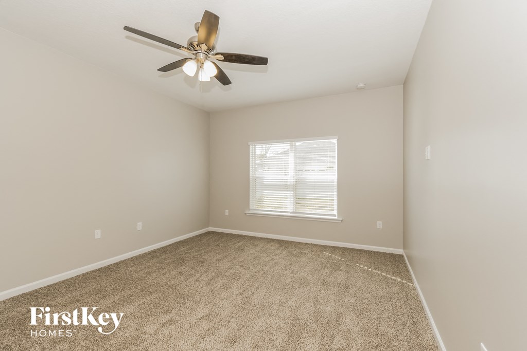 a bedroom with carpet and a ceiling fan
