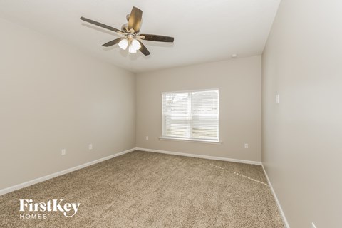 a bedroom with carpet and a ceiling fan