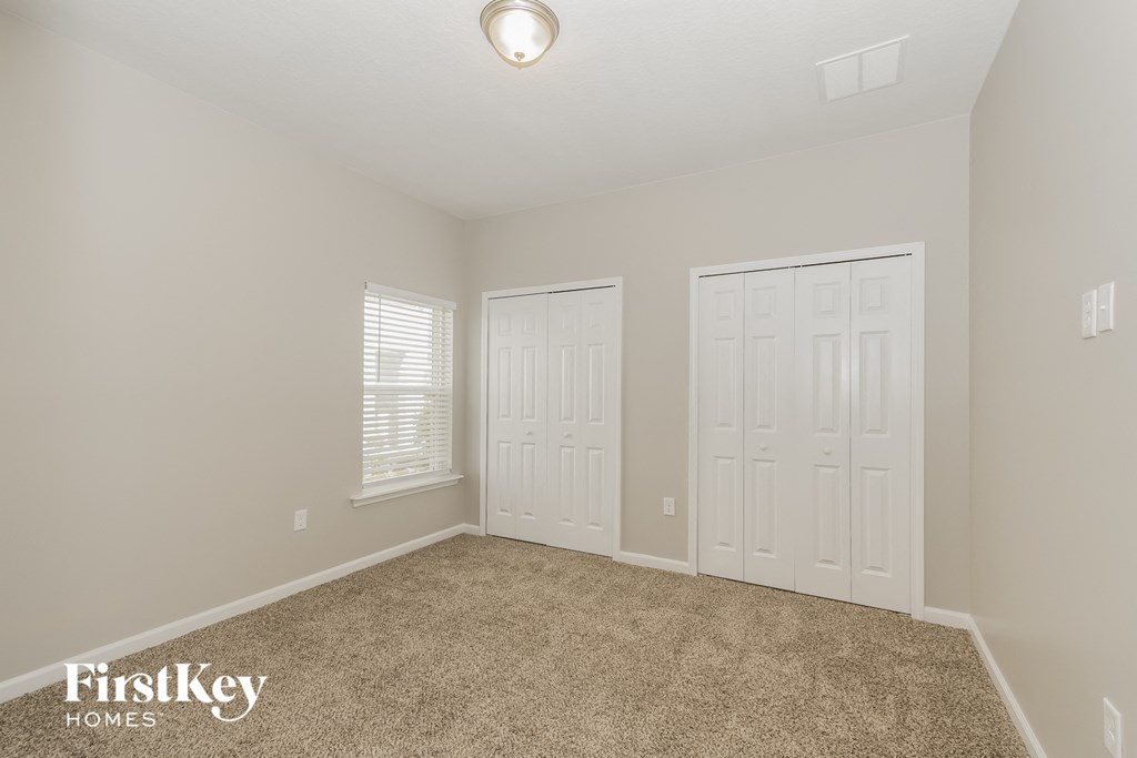 the second bedroom has two closets and a carpeted floor