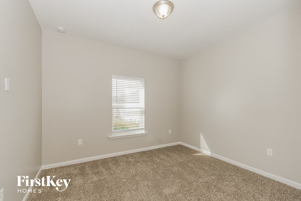 a empty room with carpet and a window