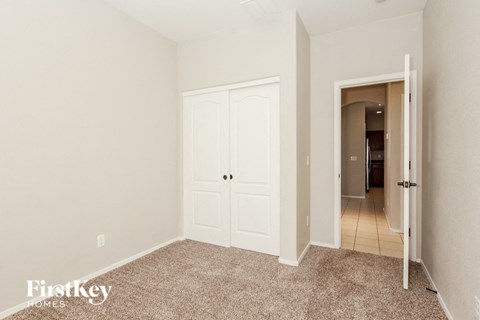 a bedroom with two closets and a door to a hallway