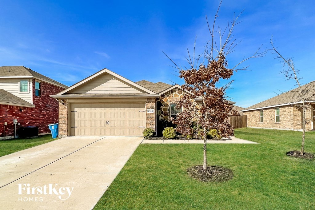 a home with a garage and a tree in the yard