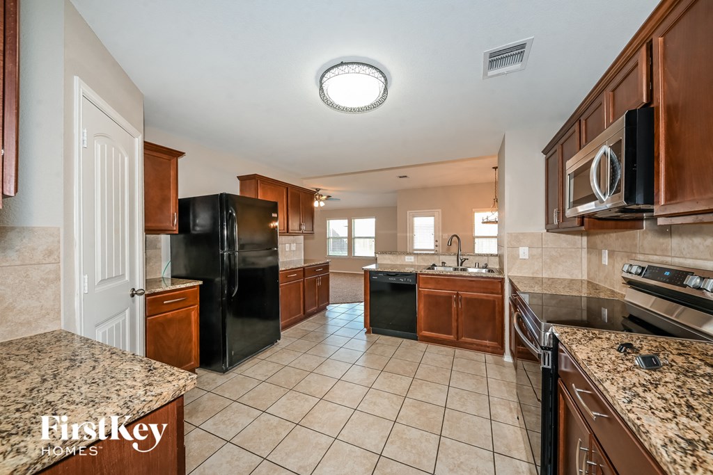 a kitchen with black appliances and granite counter tops