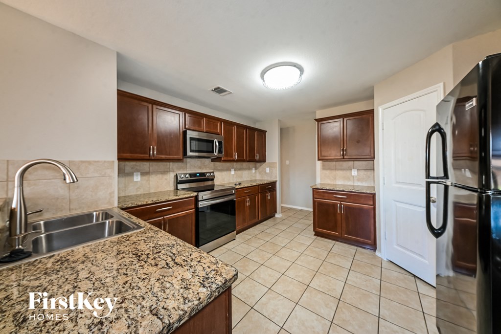 a kitchen with granite counter tops and wooden cabinets