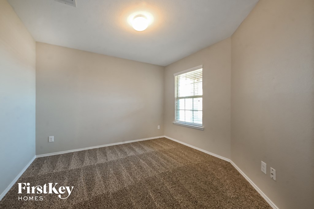 the spacious living room with carpet and a window