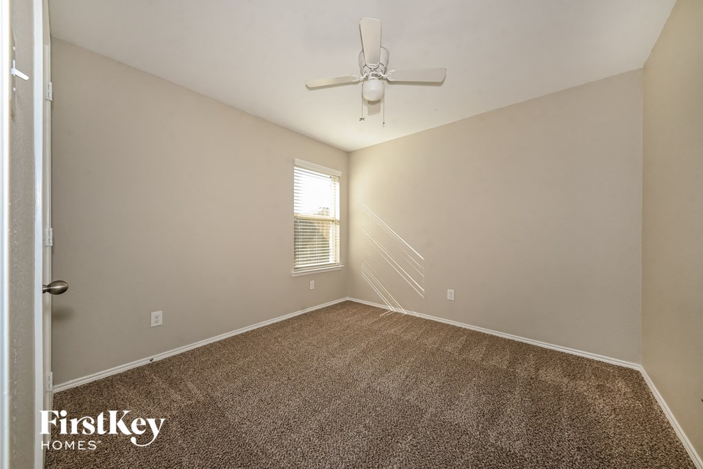the living room of an empty house with a ceiling fan