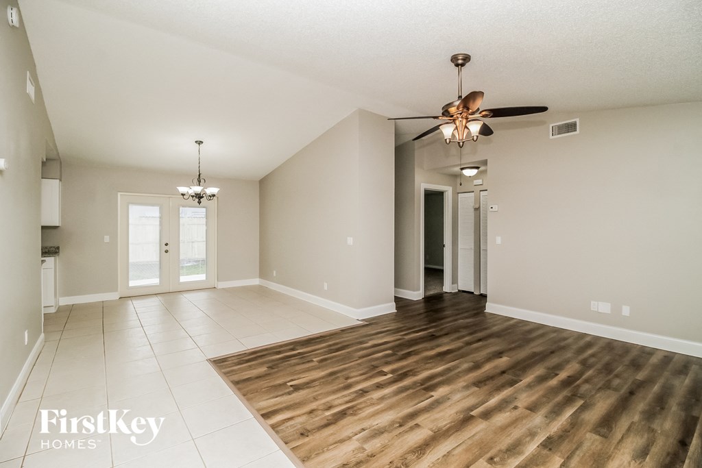 A spacious room with a ceiling fan and wooden flooring.