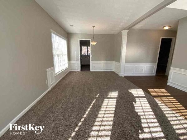 an empty living room with light coming through a window