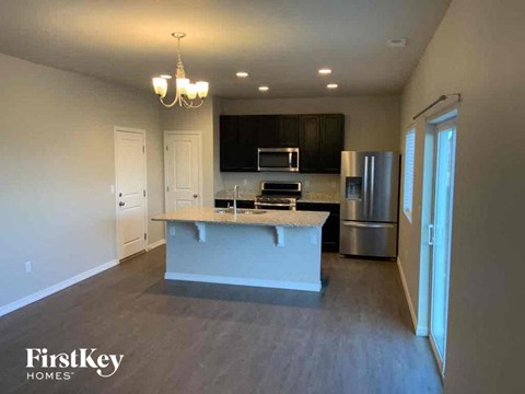 a kitchen with a large island and a stainless steel refrigerator