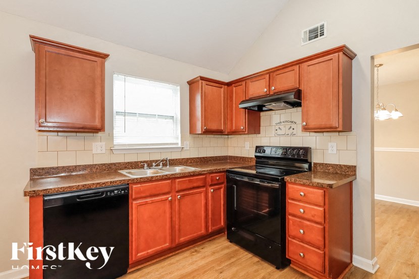 a kitchen with wooden cabinets and black appliances and a counter top
