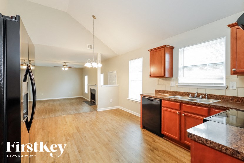 an empty kitchen with wood flooring and stainless steel appliances