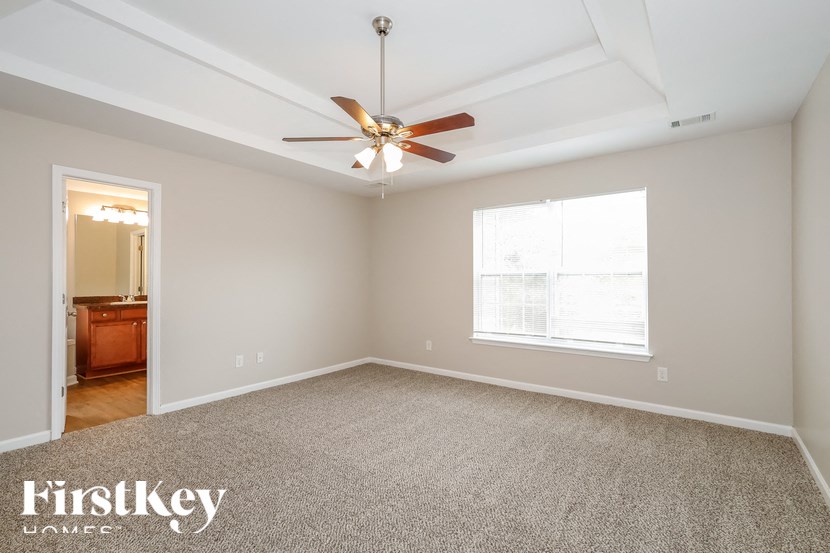 the living room of an empty house with a ceiling fan