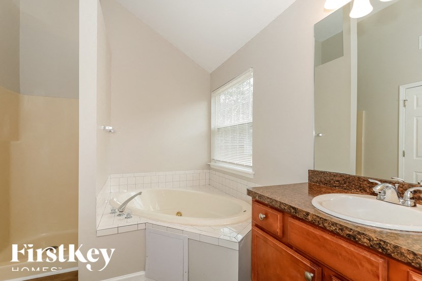 a bathroom with a tub and a sink and a mirror