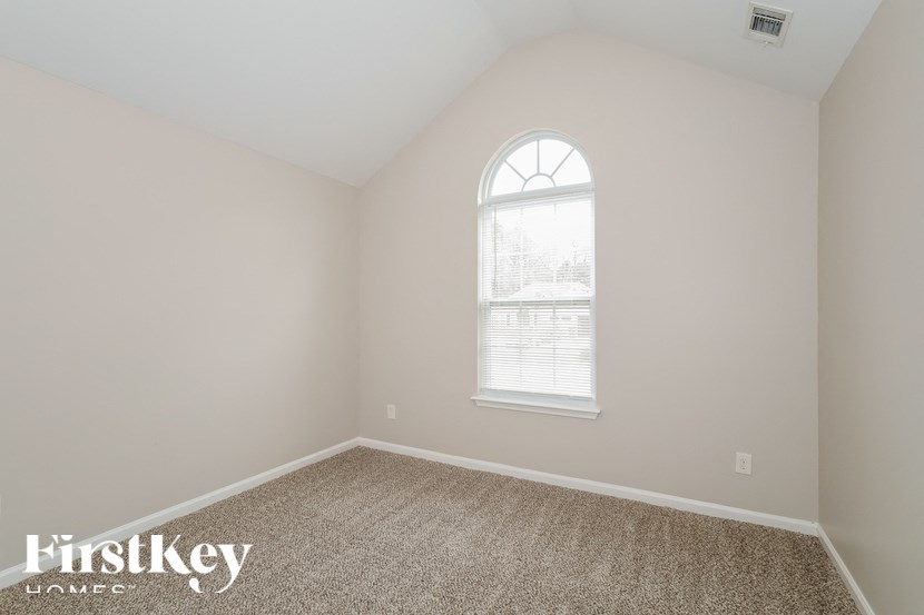 the second bedroom is spacious and has a window and carpet