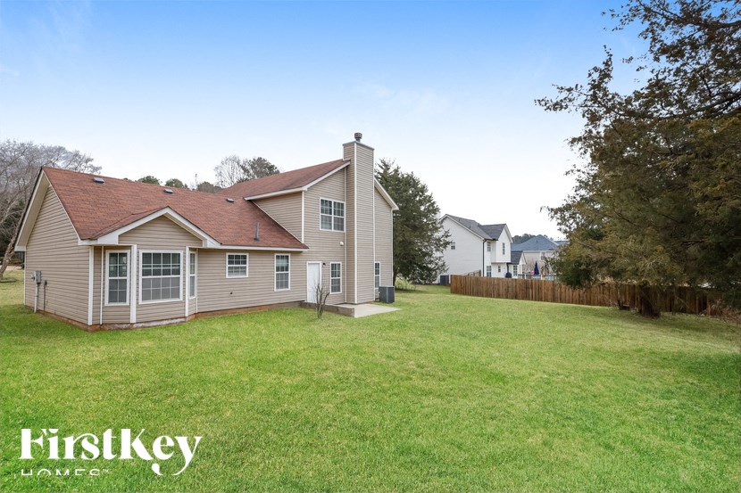 a home with a yard and a house in the background