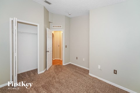 a bedroom with carpet and a door to a closet