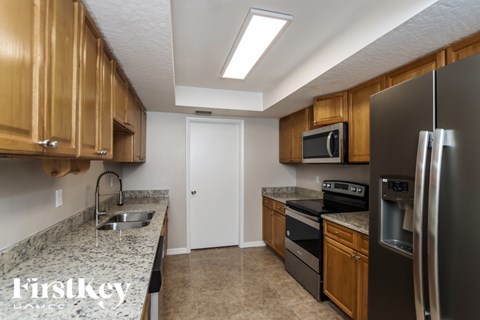 A kitchen with wooden cabinets and a granite countertop.