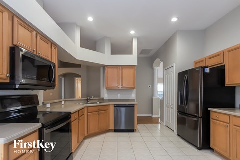 A kitchen with wooden cabinets and black appliances.