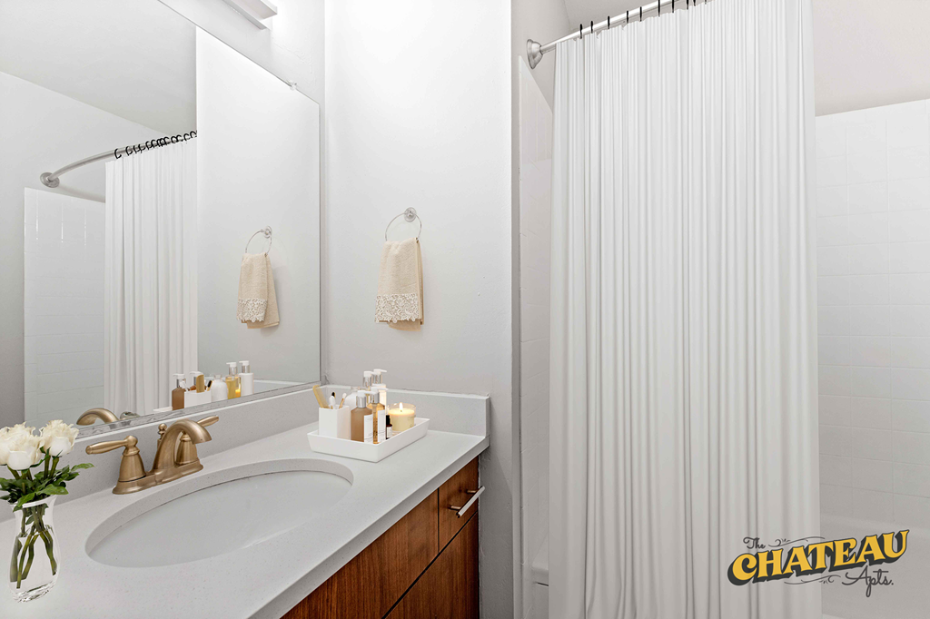 a bathroom with a shower and a sink and a mirror