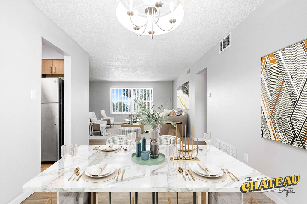 a dining room with a marble table and a chandelier