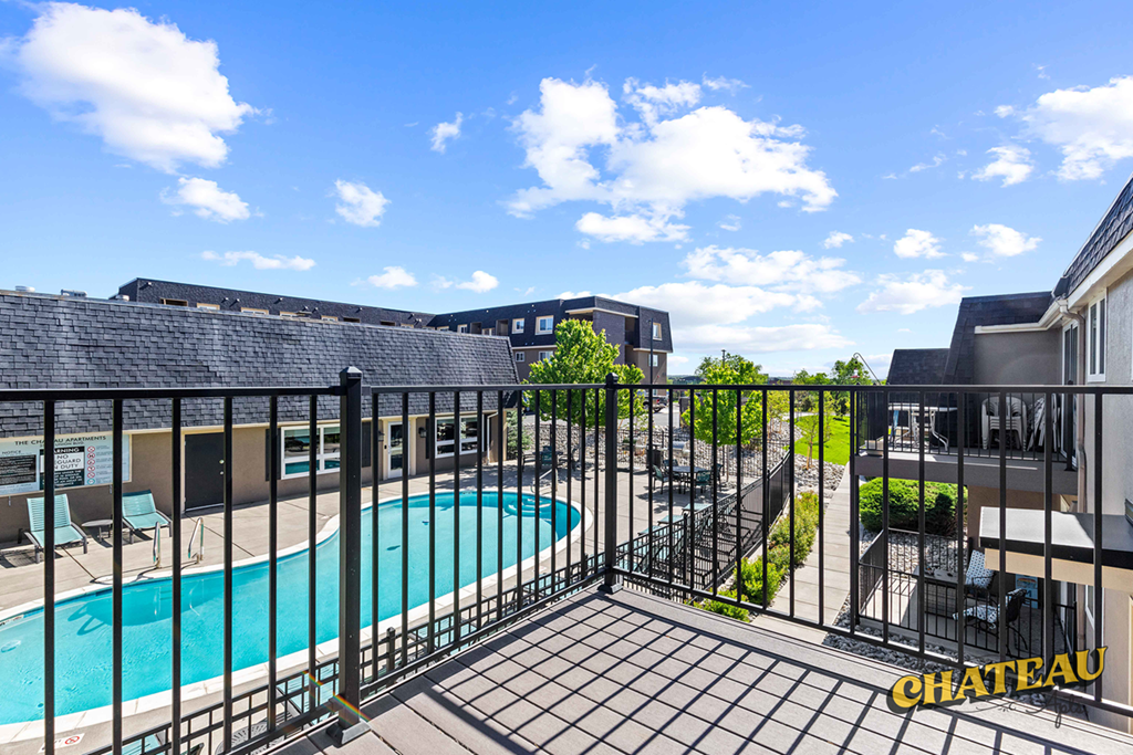 a view of the pool from a balcony at the chateau apartments