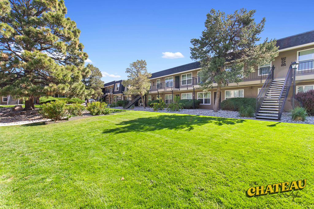 a large green lawn in front of a building with stairs