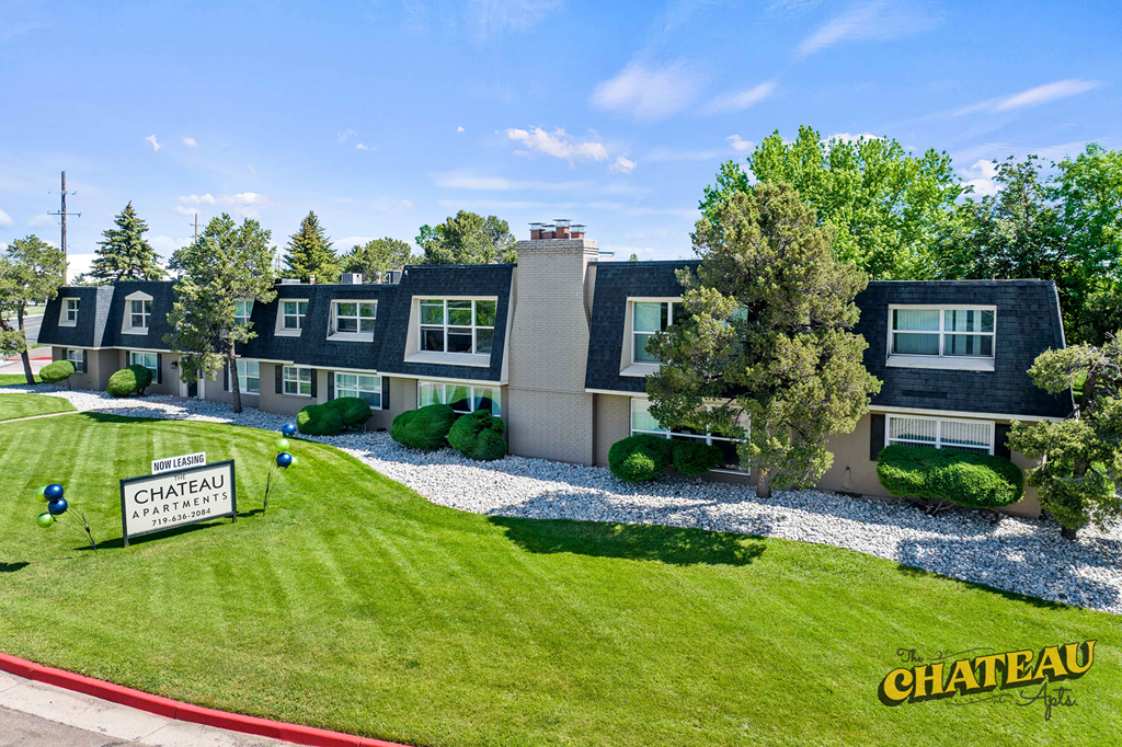 an aerial view of a home with a green lawn and a court house