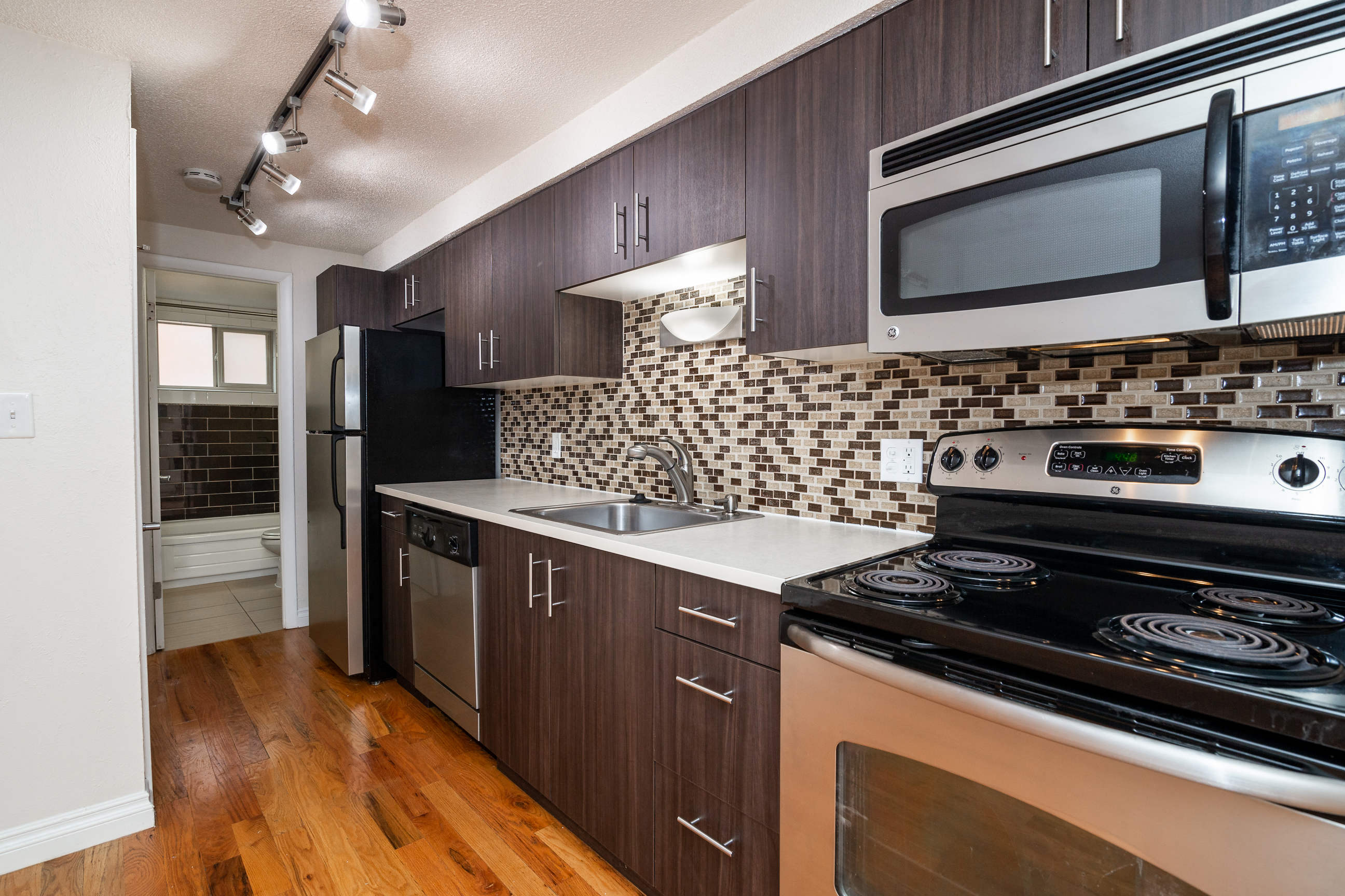 a kitchen with a stove and a microwave and a refrigerator