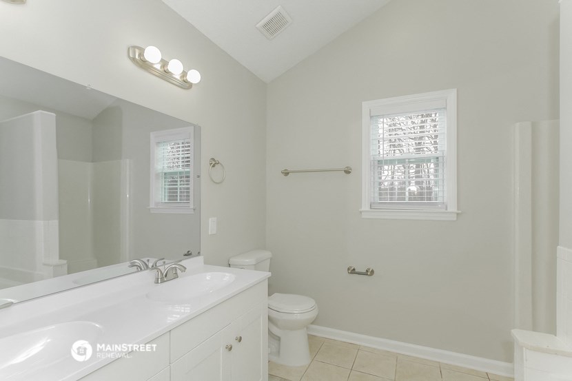 a bathroom with a large mirror and a toilet and a sink