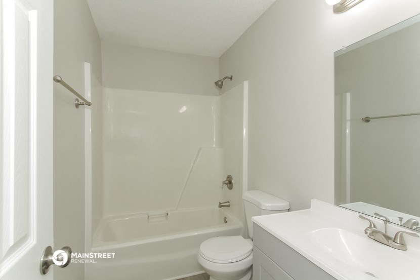 a white bathroom with a shower and a sink and a toilet