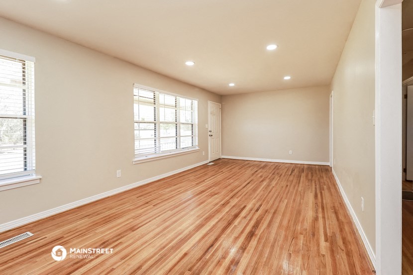 the living room and dining room of a new home with wood flooring