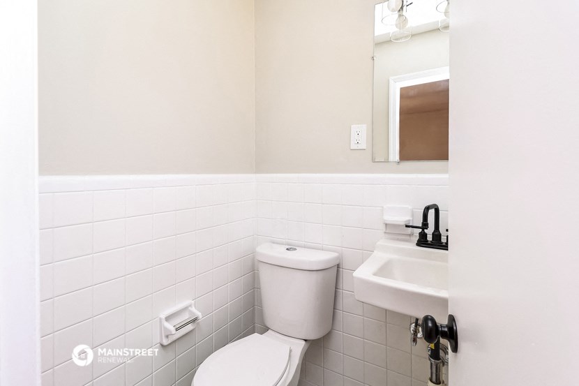 a white bathroom with a toilet and a sink