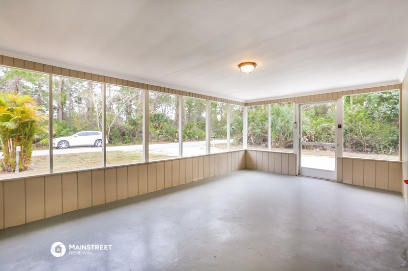 an empty room with large windows and a concrete floor