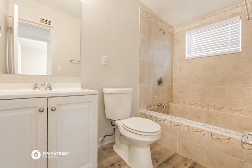 a bathroom with a toilet and a sink and a shower