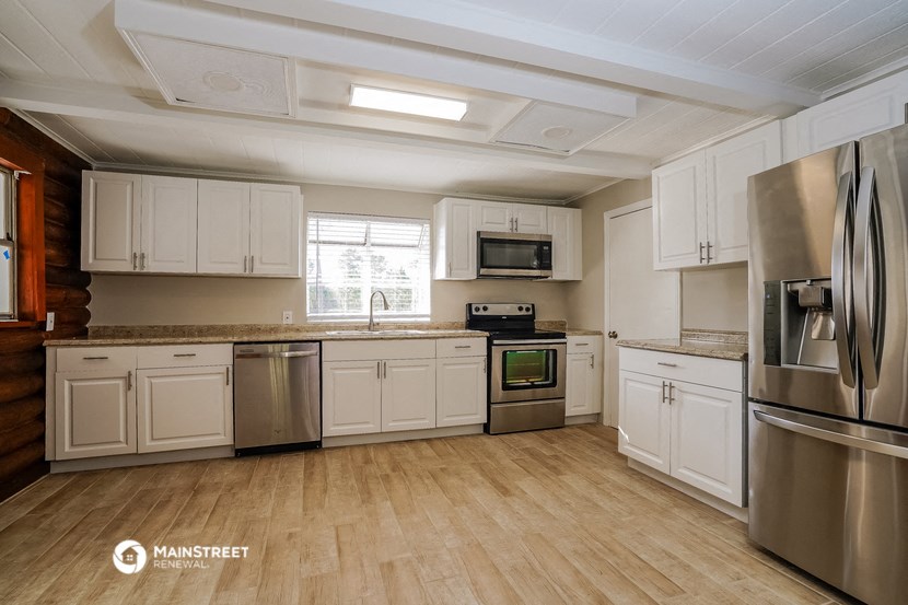 a kitchen with white cabinets and stainless steel appliances