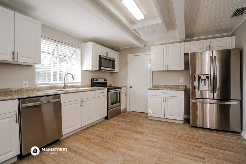 a kitchen with white cabinets and stainless steel appliances